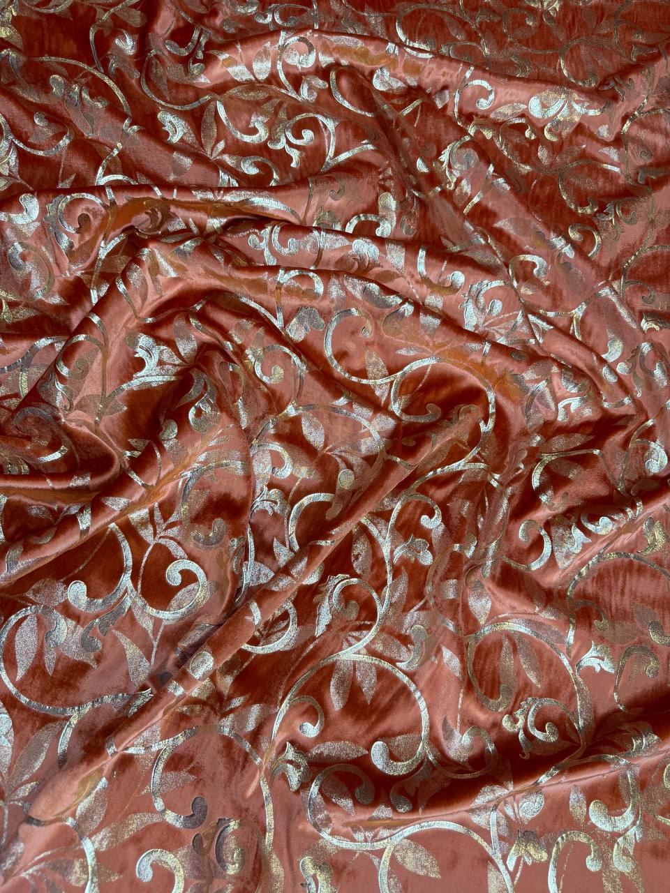 Terracotta Scroll fabric: ornamental scrollwork in terracotta and pale metallic tones. Original fabric photograph.