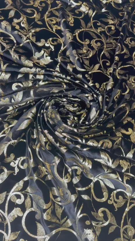 Original video showing black & gold scroll fabric in movement, with ornamental scrollwork.